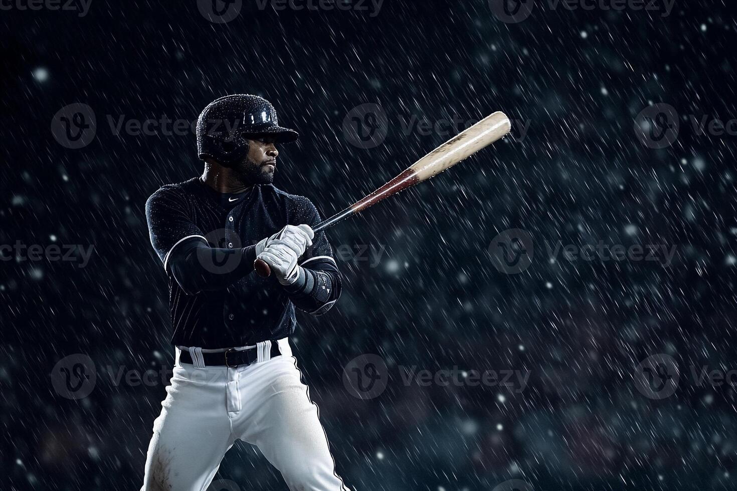 A baseball player in the rain holding a bat photo