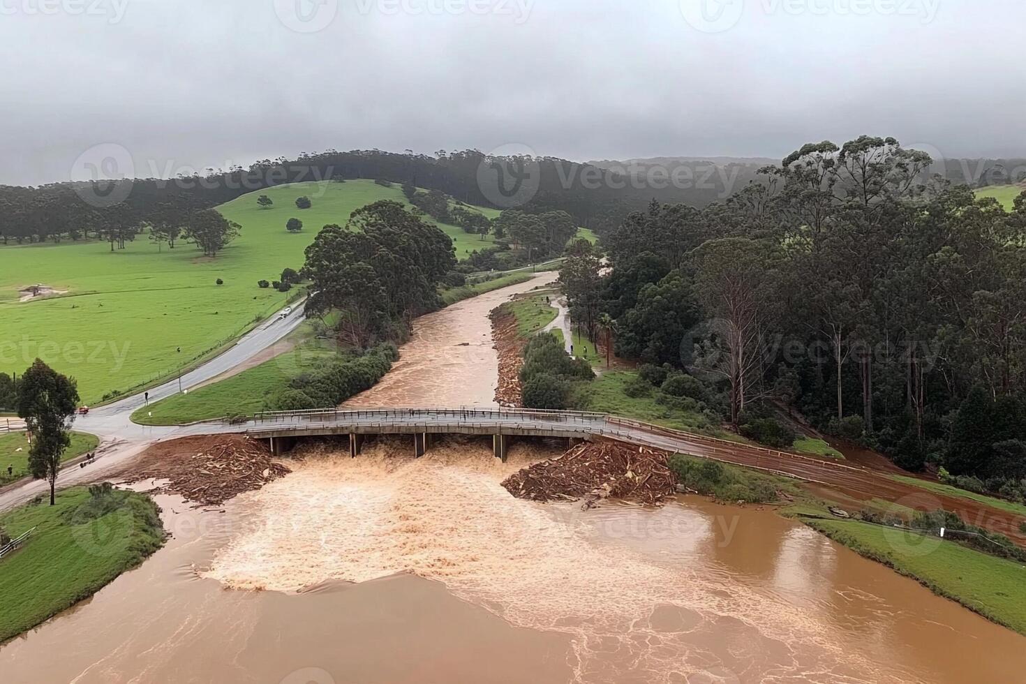 A river is flowing through a field with a bridge photo