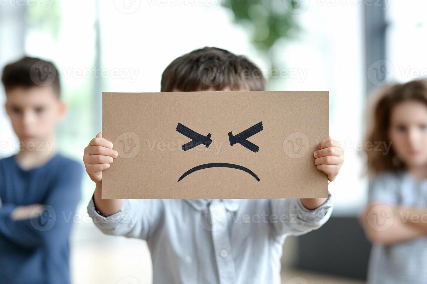 A child holding a paper with an angry face photo