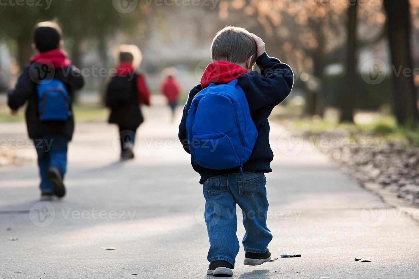 A young boy walking down a path with a backpack photo