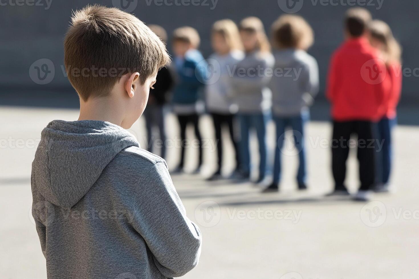 A young boy standing in front of a group of people photo
