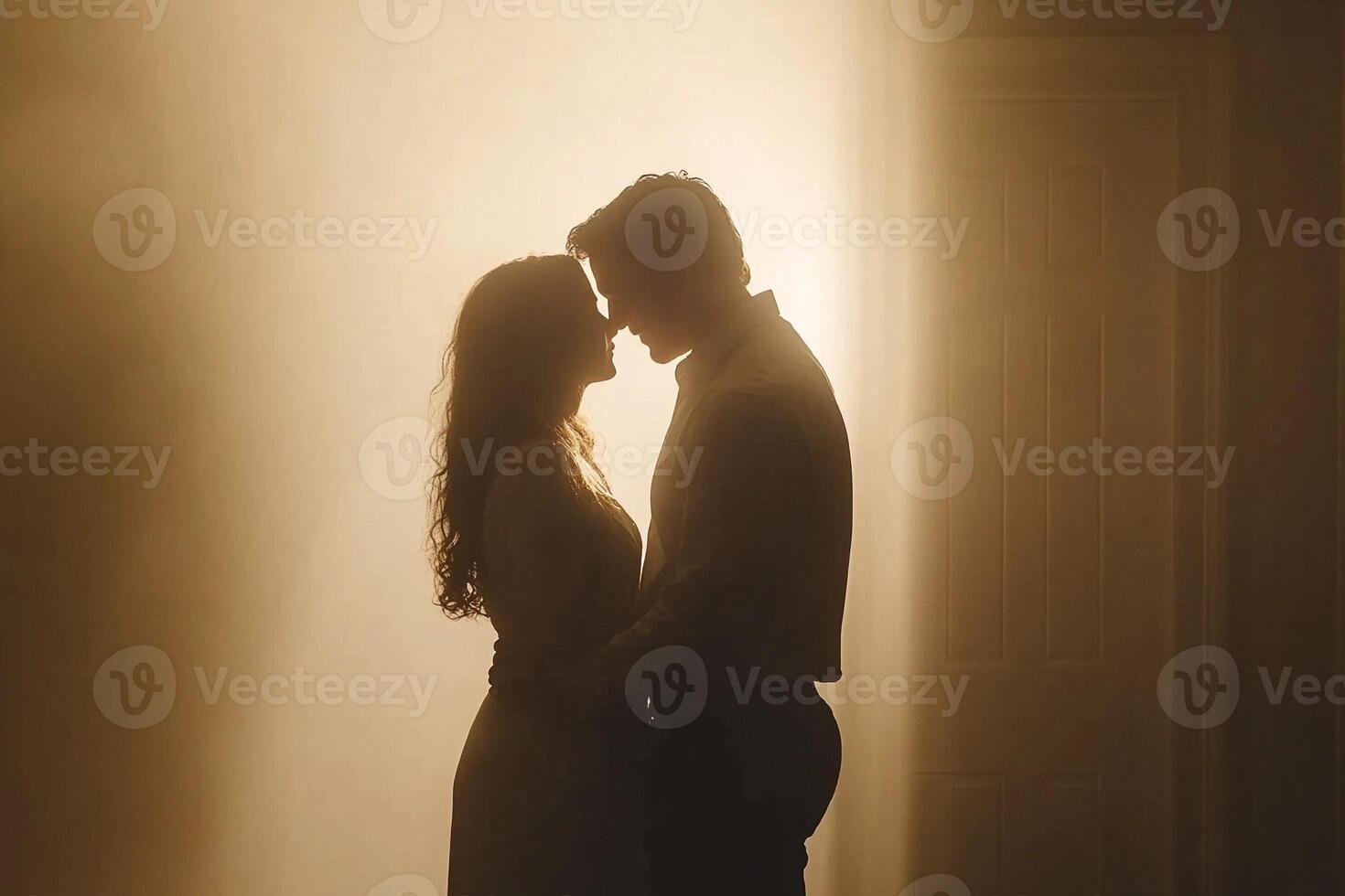 A couple is silhouetted against the light coming from the door photo