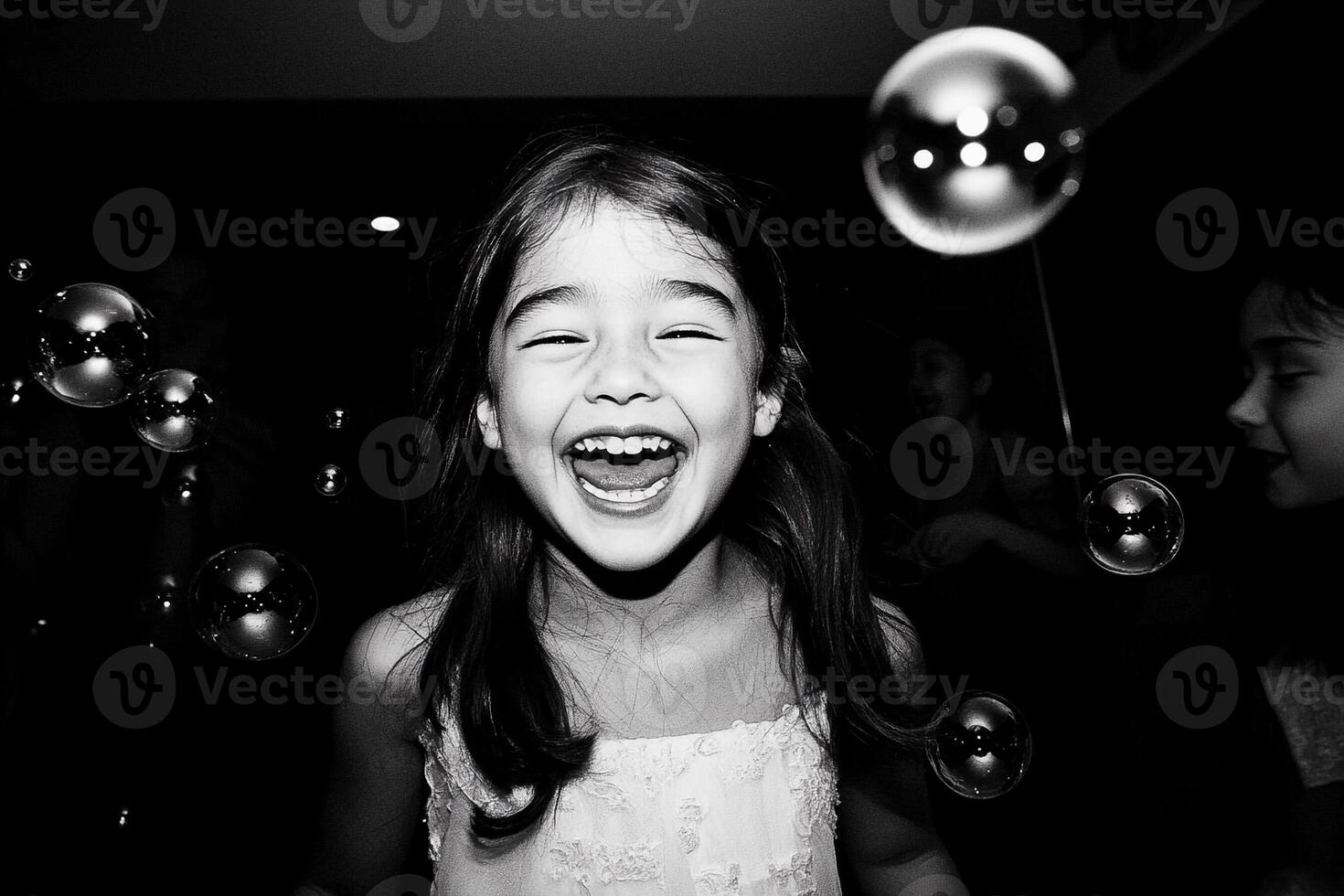 A young girl laughing as she is surrounded by bubbles photo