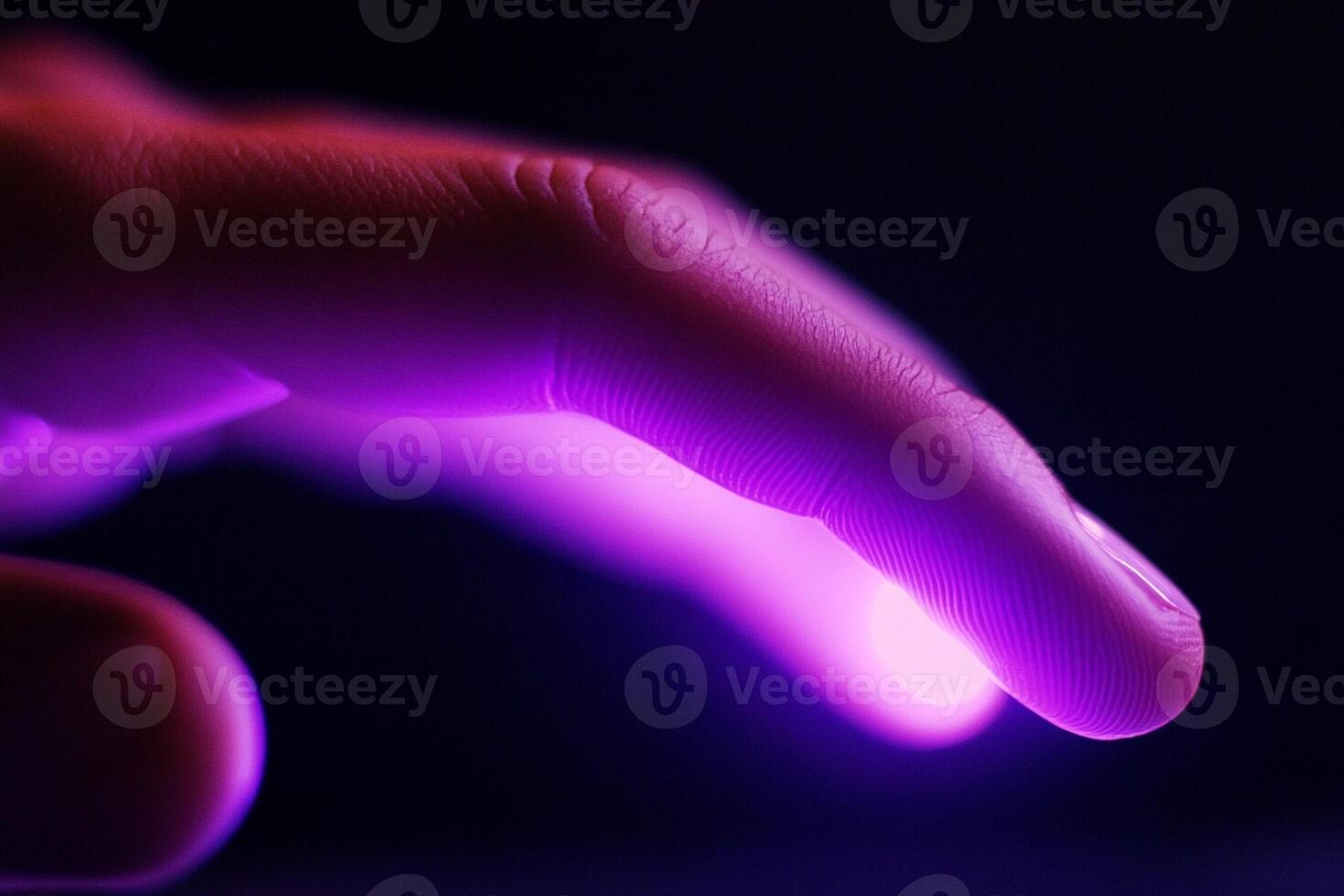A person's hand is glowing with purple light photo