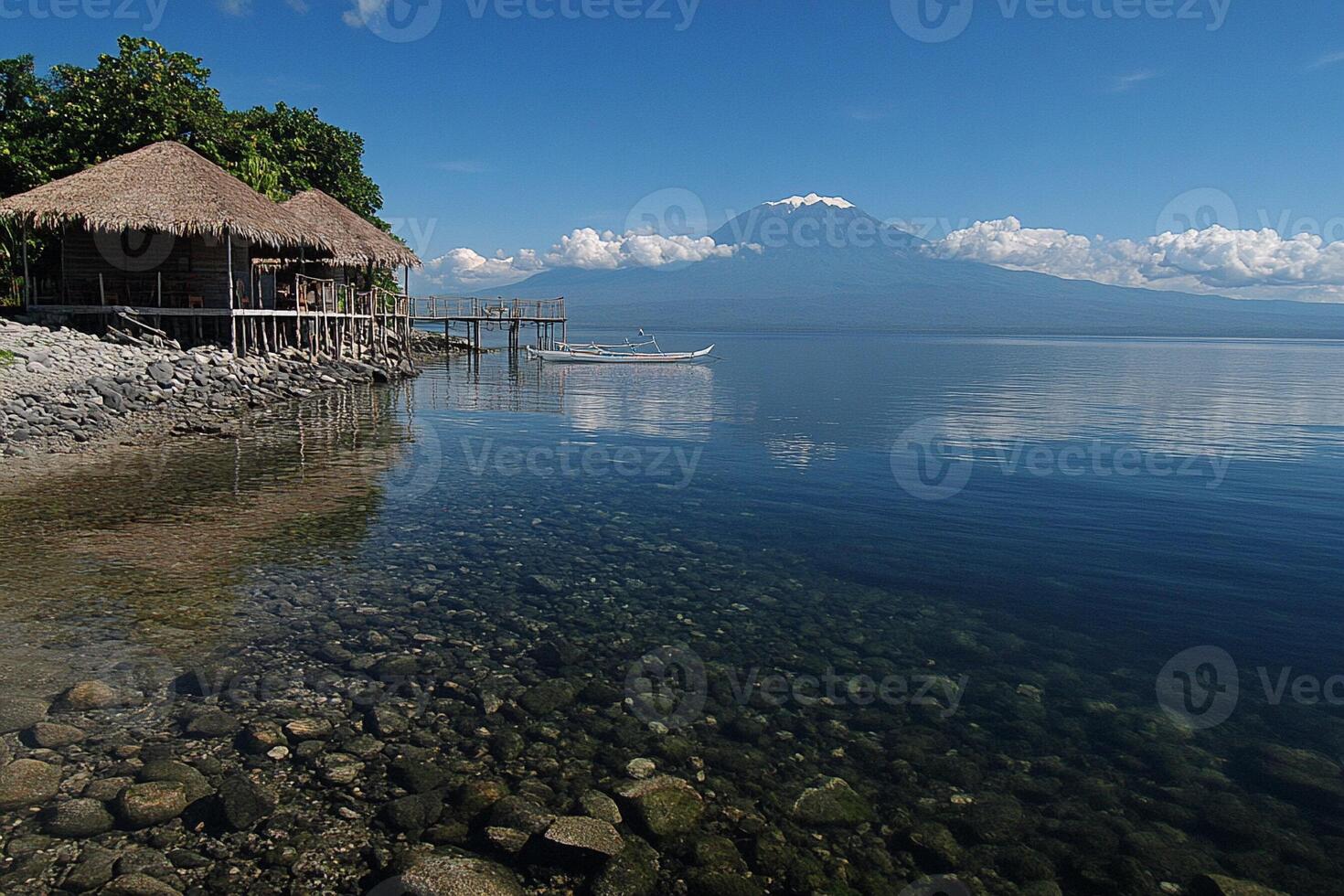 A boat is sitting on the shore of a lake photo