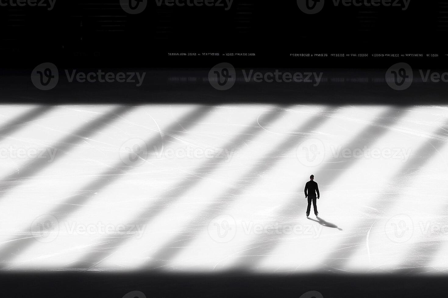 A man stands in the shadows of an ice rink photo