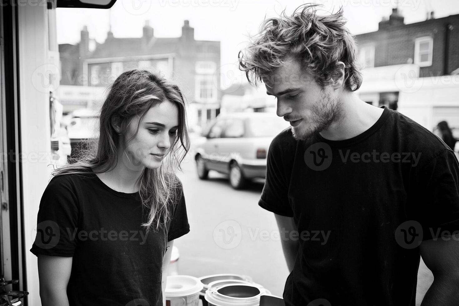A man and woman standing next to each other in a black and white photo