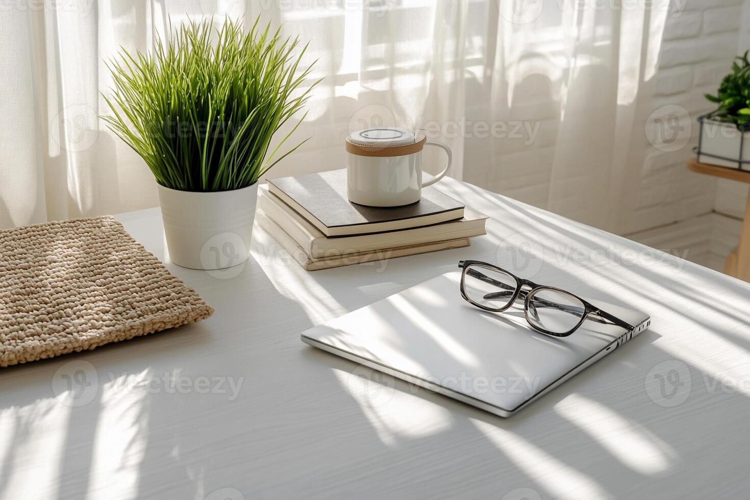 A desk with a book, coffee cup, and plant photo