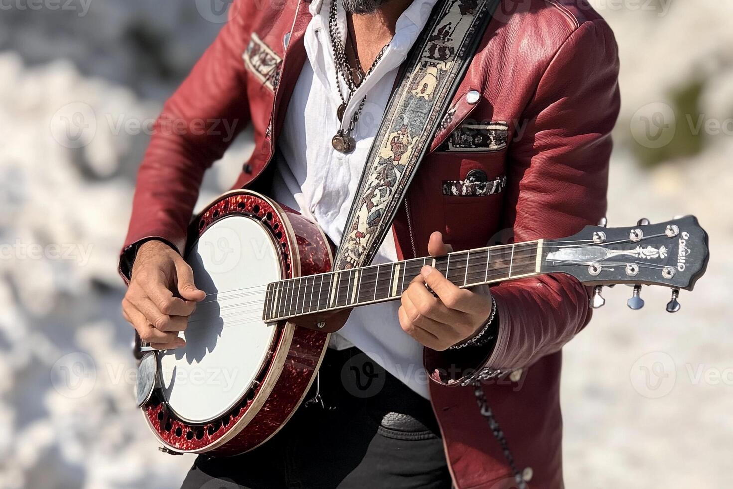 A man in a red jacket playing a banjo photo