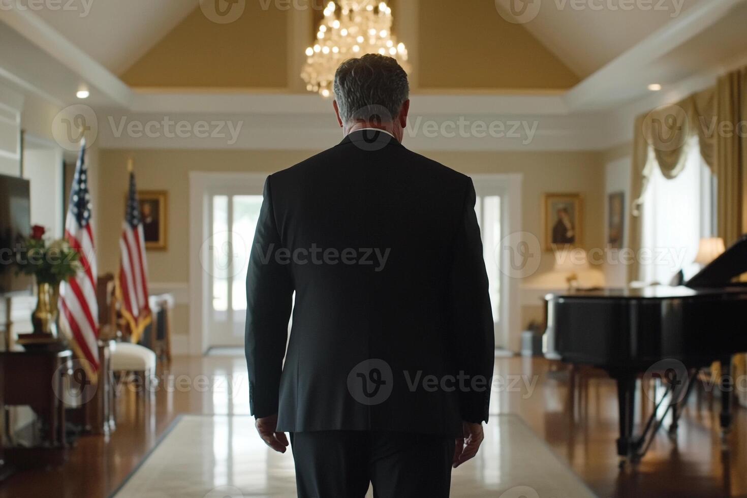 A man in a suit and tie walking through a large room photo