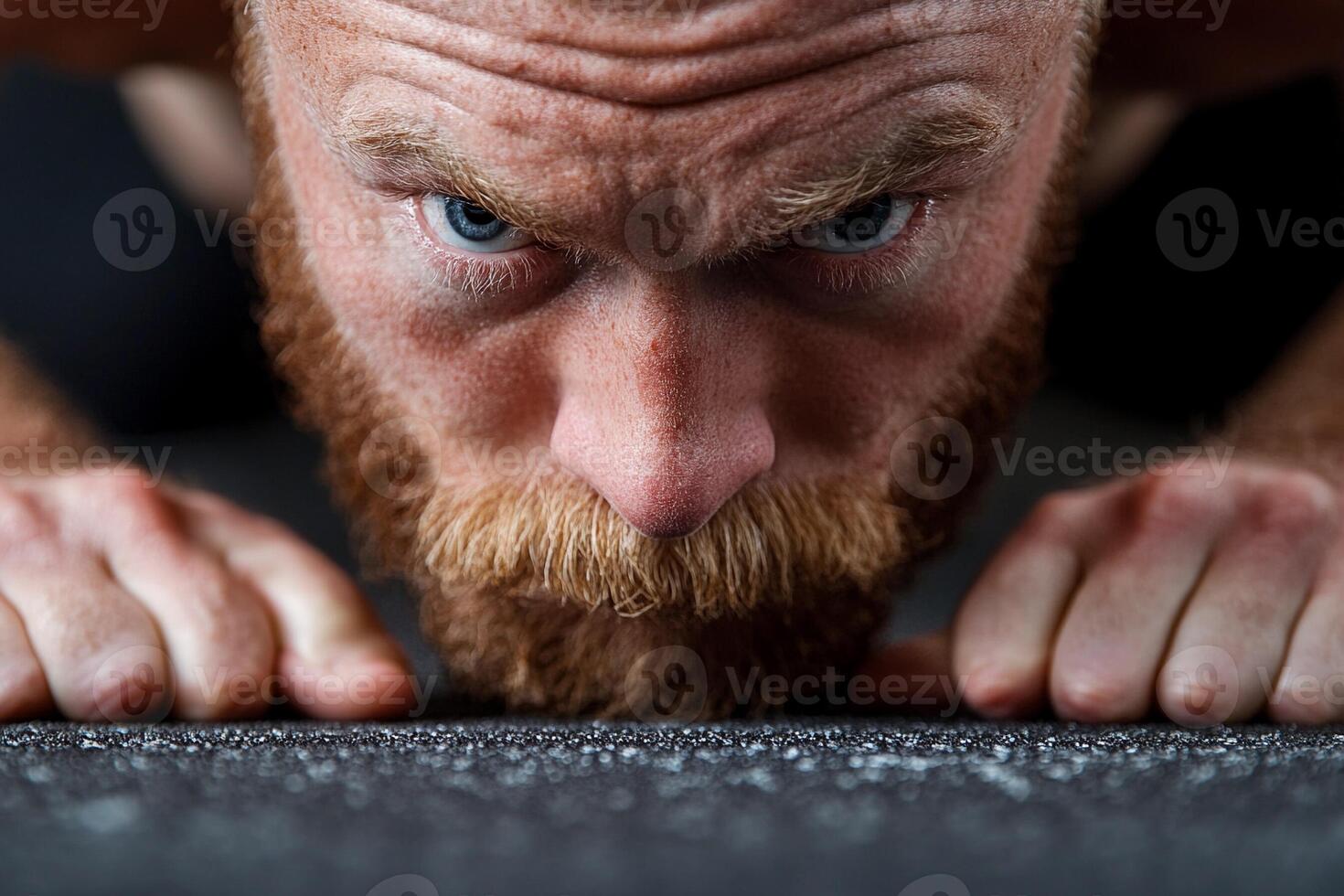 A man with a beard and a red beard is doing push ups photo