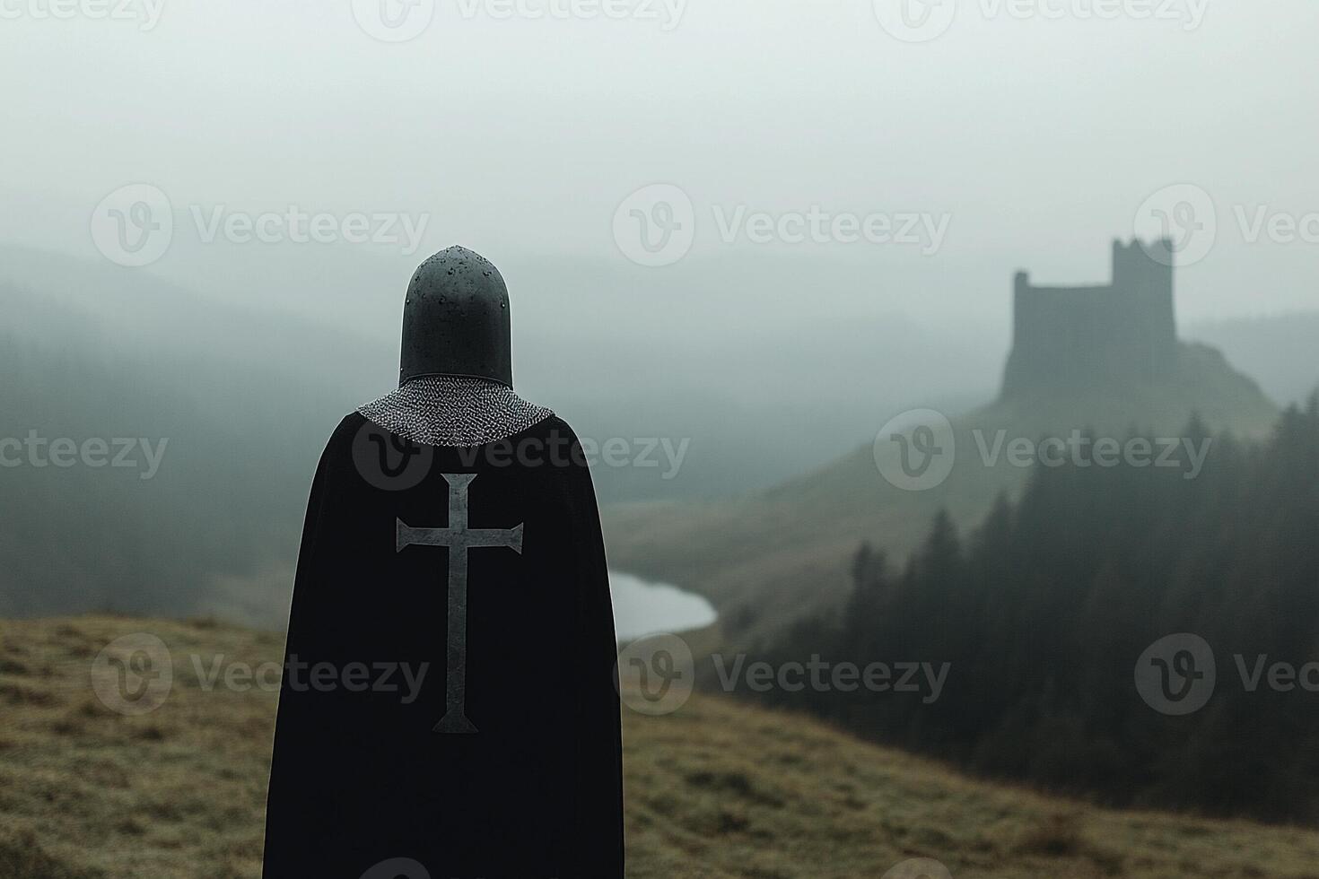A person in a black cloak standing on a hill overlooking a castle photo