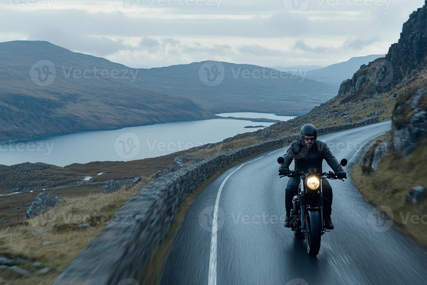 A man riding a motorcycle down a road photo