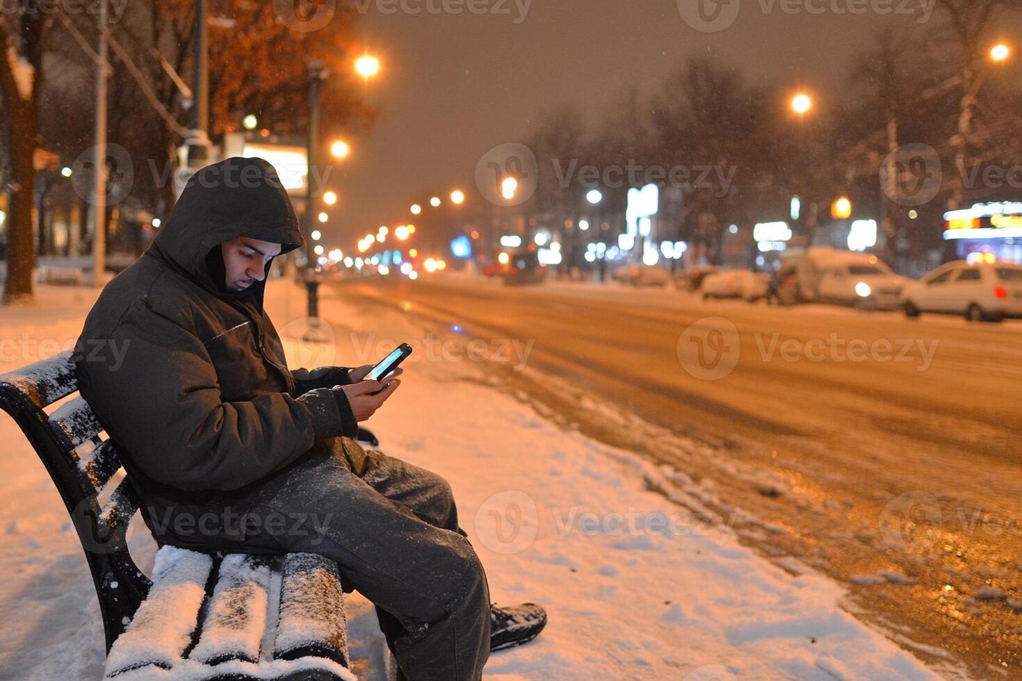 A man sitting on a bench in the snow photo