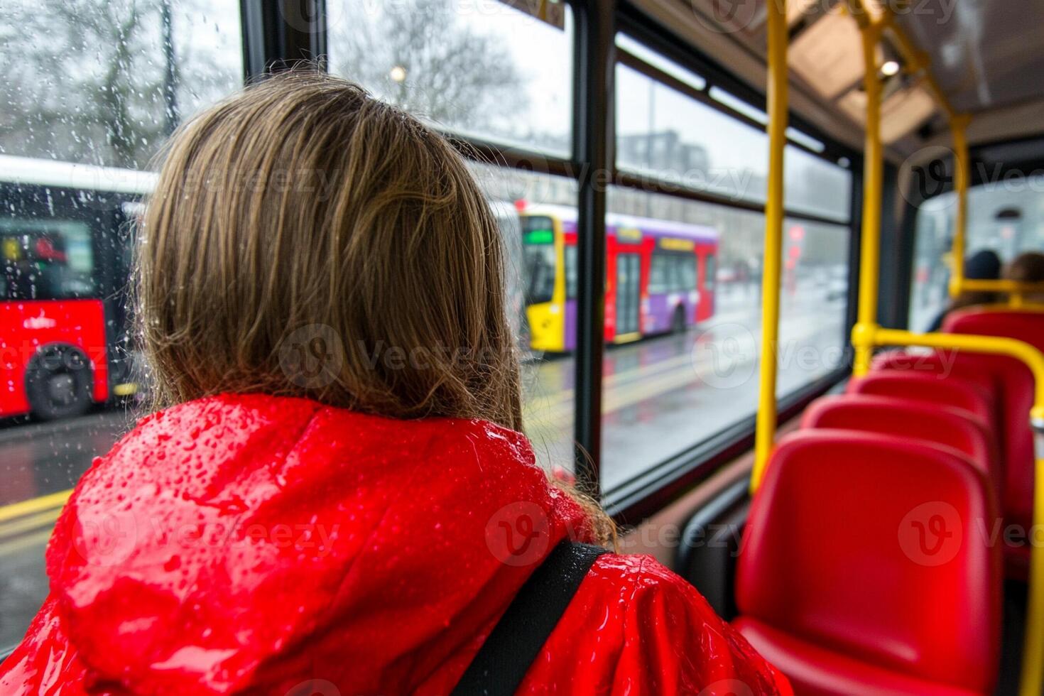 A woman in a red coat on a bus photo
