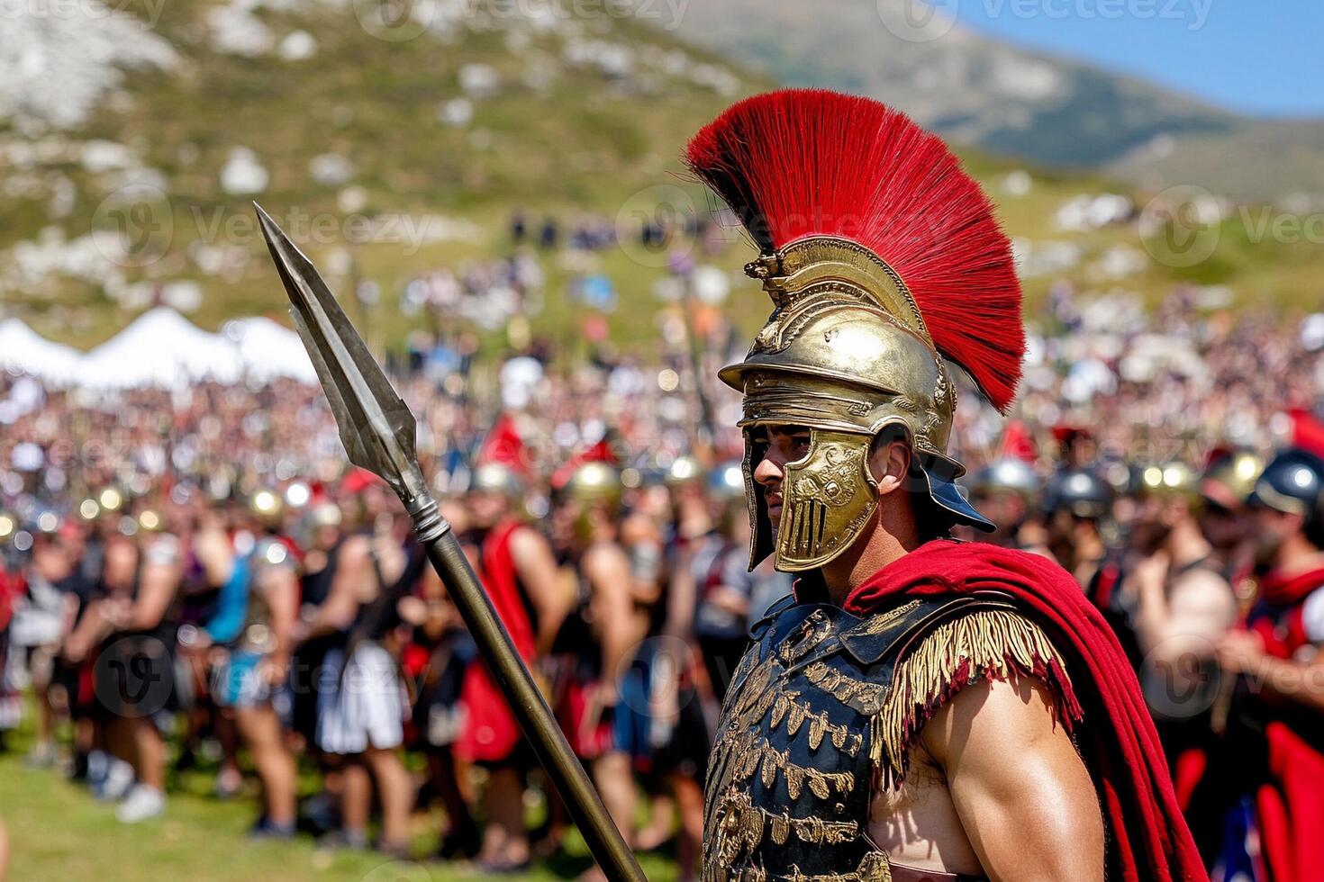 A man in a spartan costume is standing in front of a crowd photo