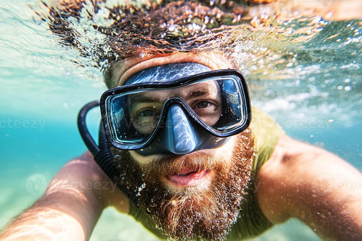 A man with a beard and goggles is underwater photo