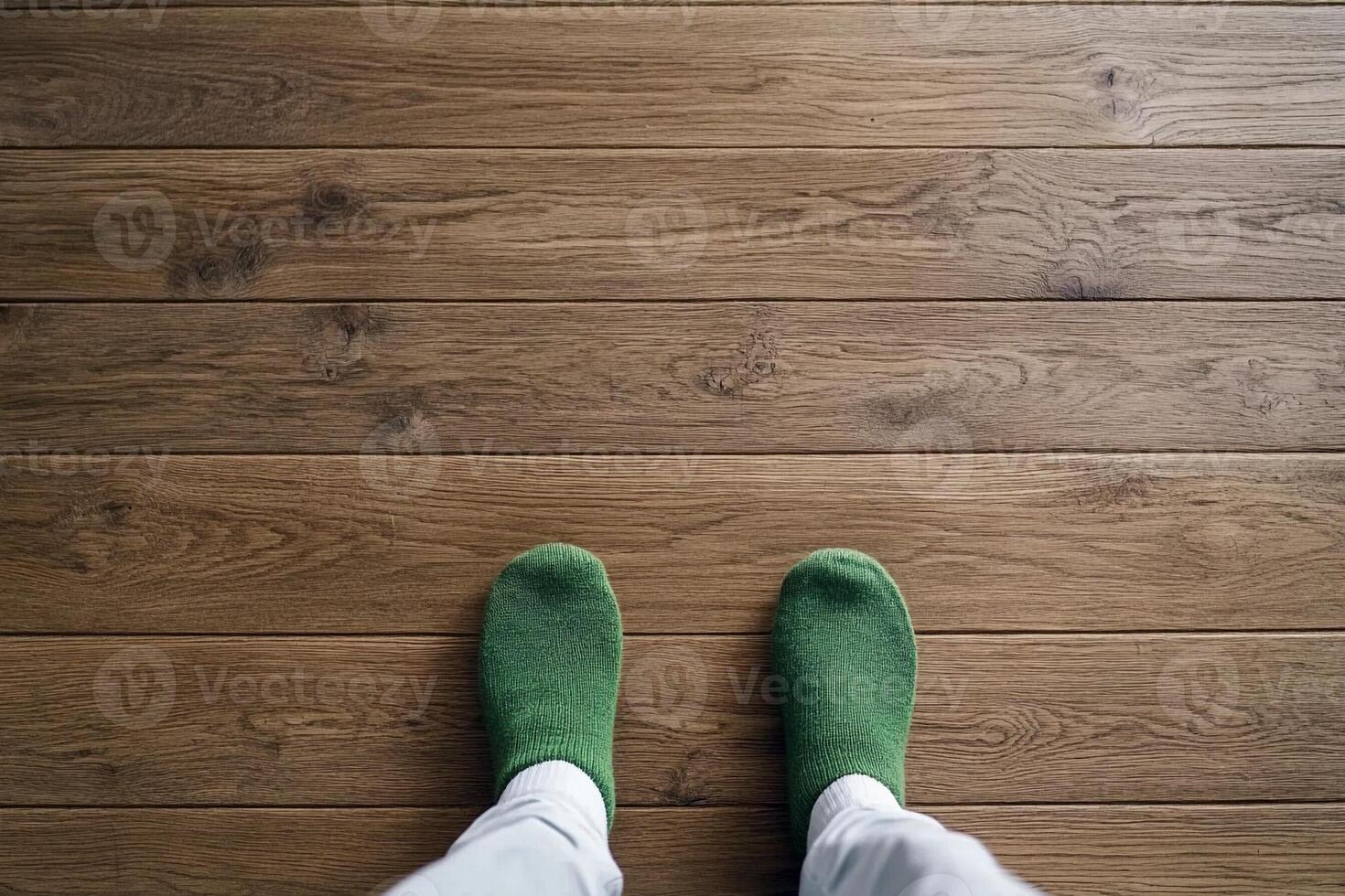 A person wearing green socks standing on a wooden floor photo