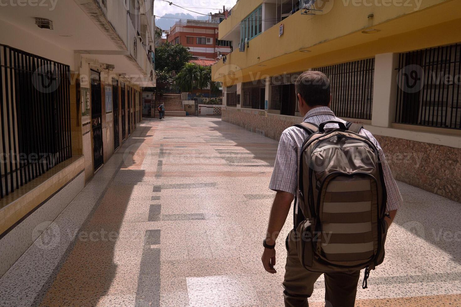 A man walking down a street with a backpack photo