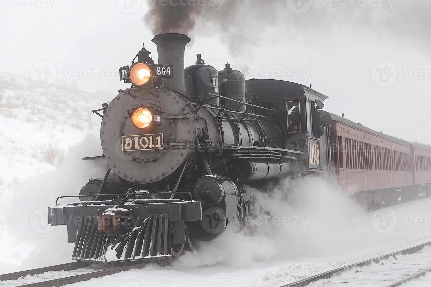 A steam engine train traveling through the snow photo