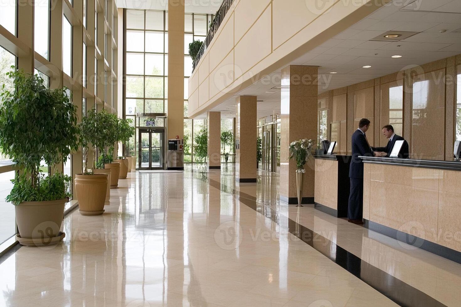 The lobby of a hotel with a reception desk and potted plants photo
