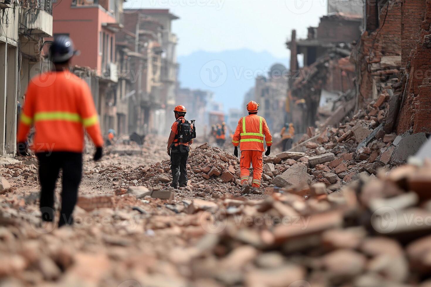 Workers walk through rubble in a city street photo