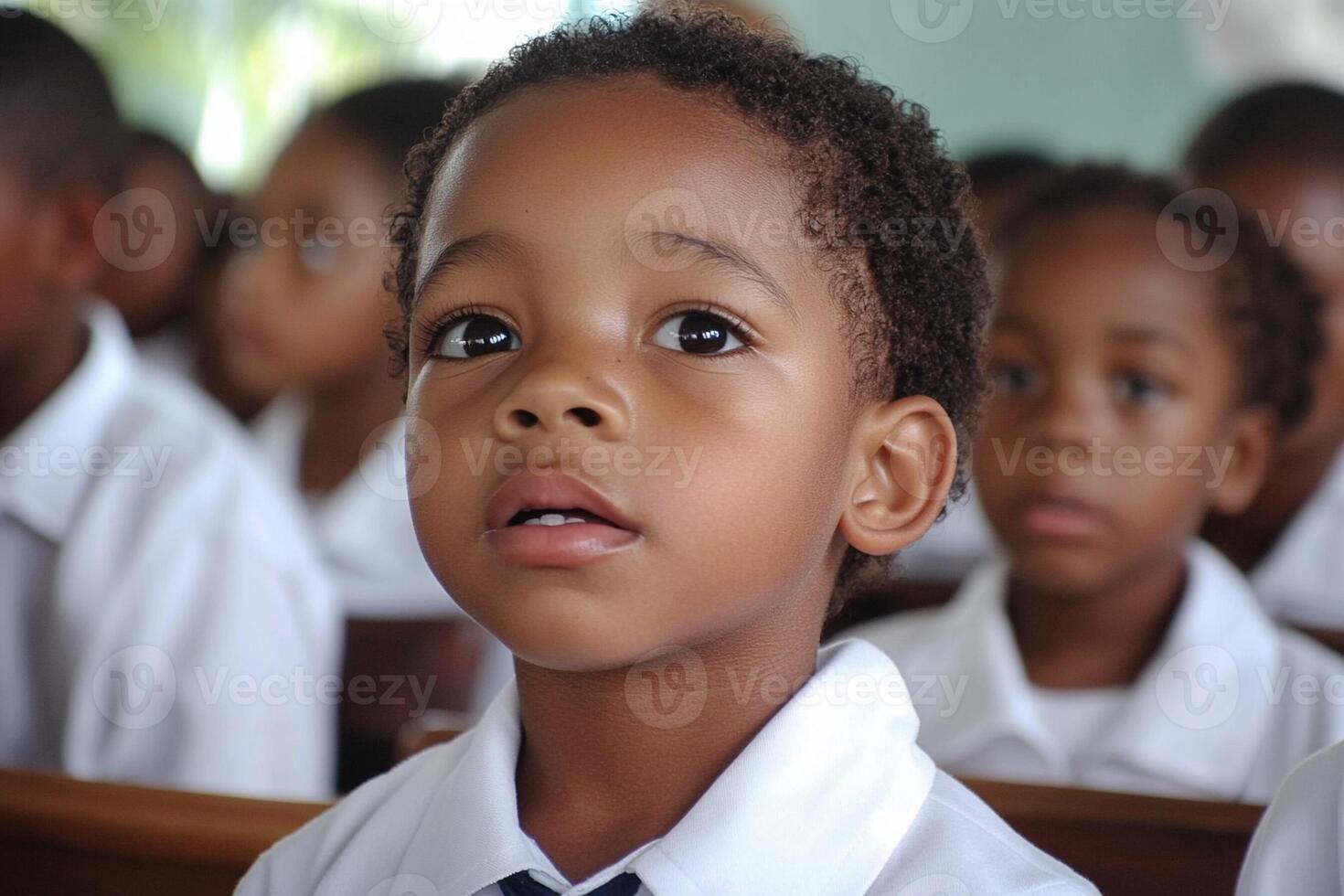 A young boy in a classroom with other children photo