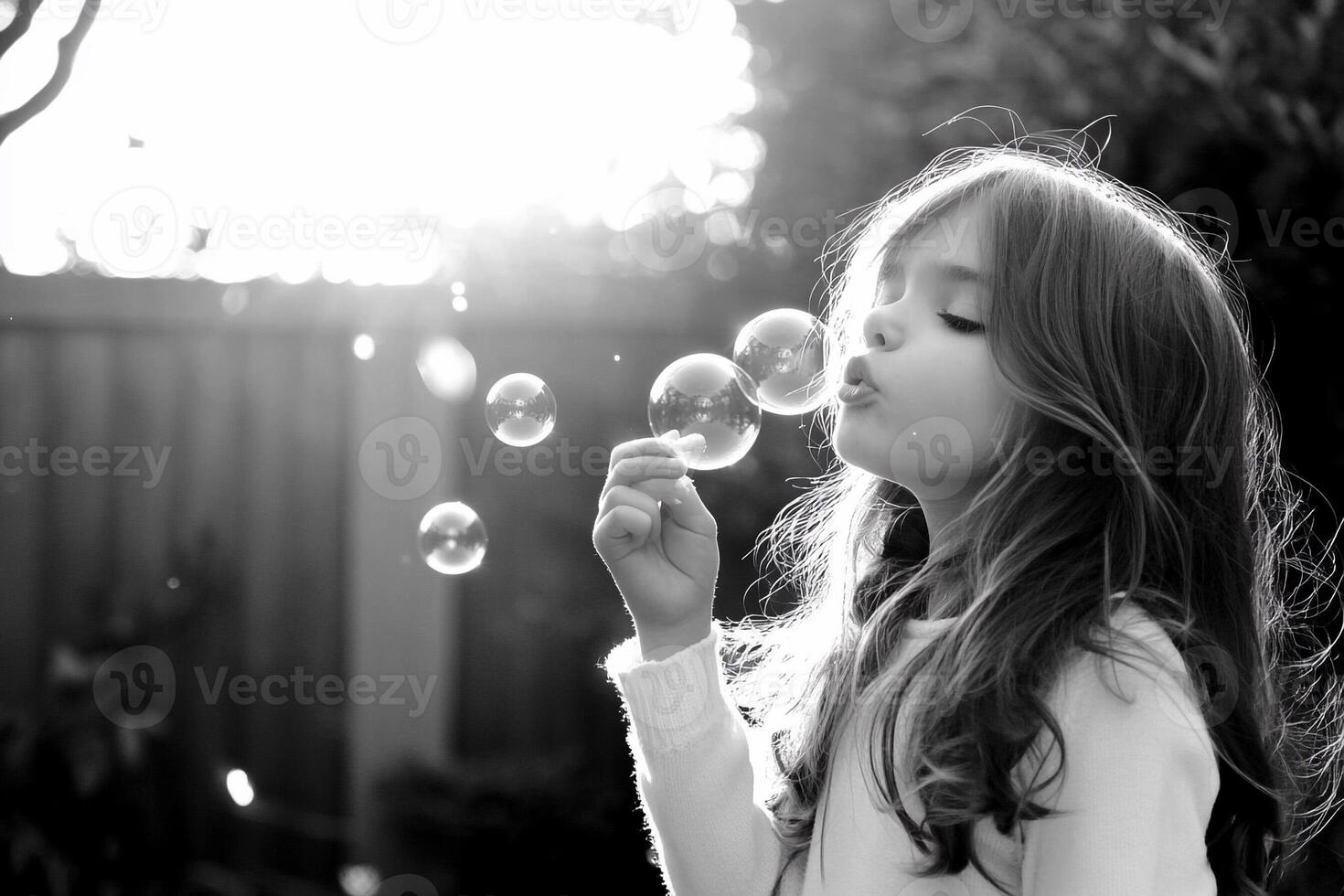 A young girl blowing bubbles in the sun photo