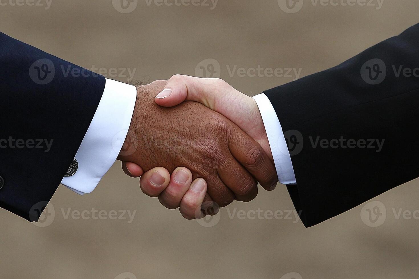 Two men shaking hands in front of a gray background photo