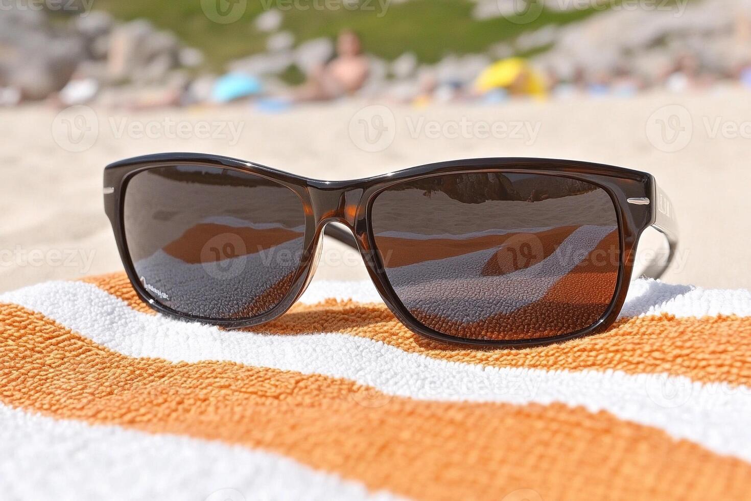 Sunglasses on a towel on the beach photo