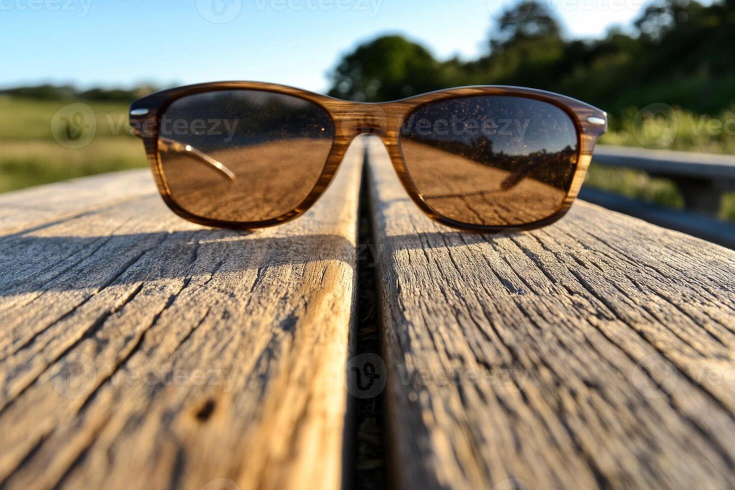 A pair of sunglasses on a wooden bench photo
