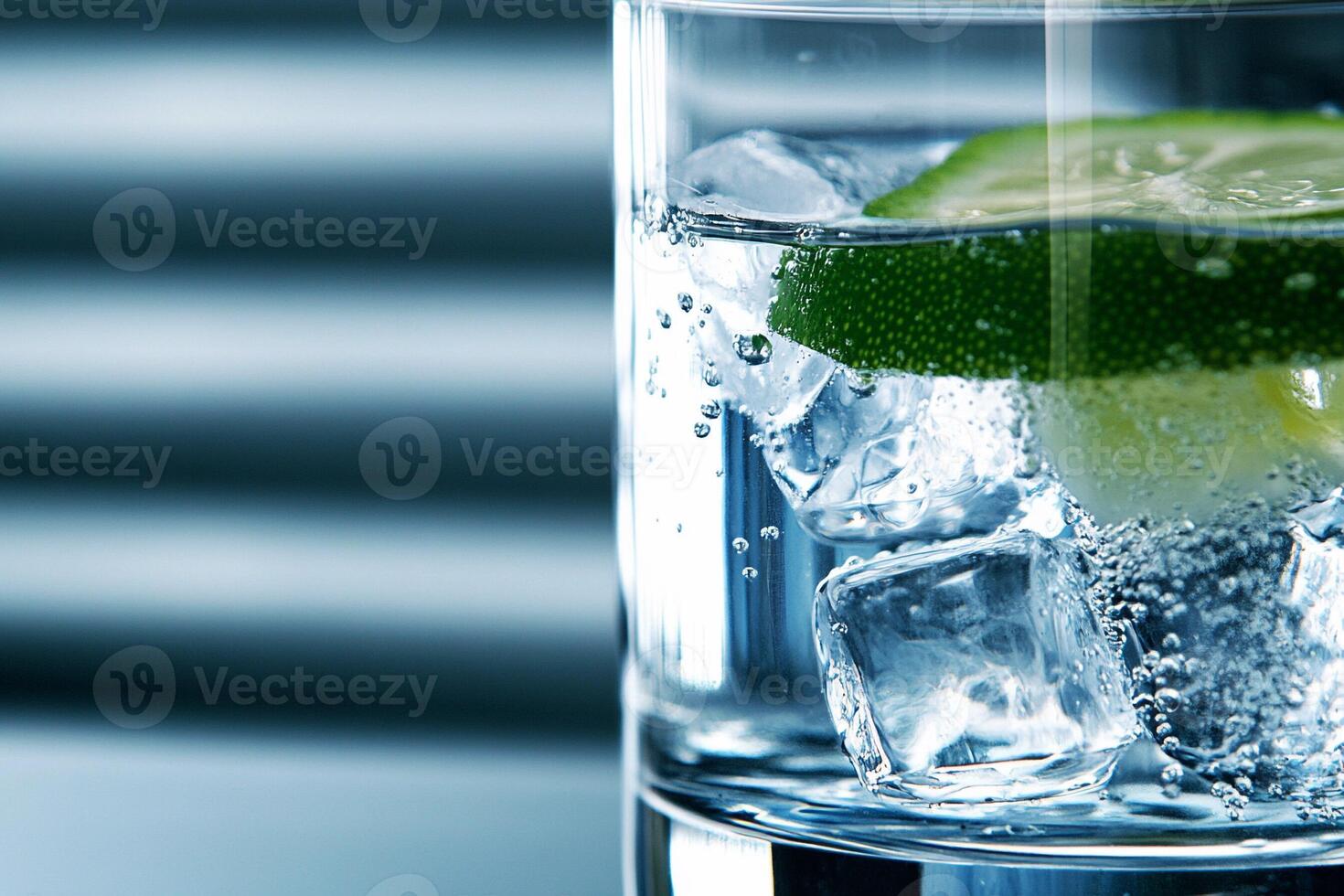 A glass of water with ice and a lime photo