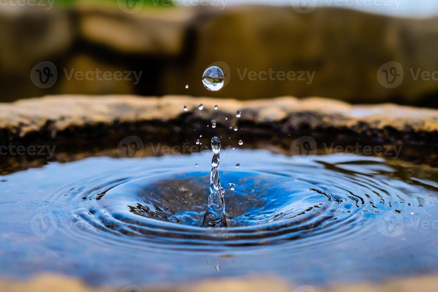 A water drop is falling into a water fountain photo