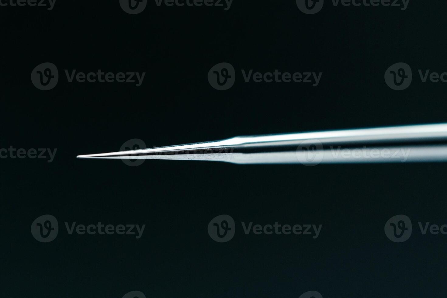 A close up of a needle on a black background photo
