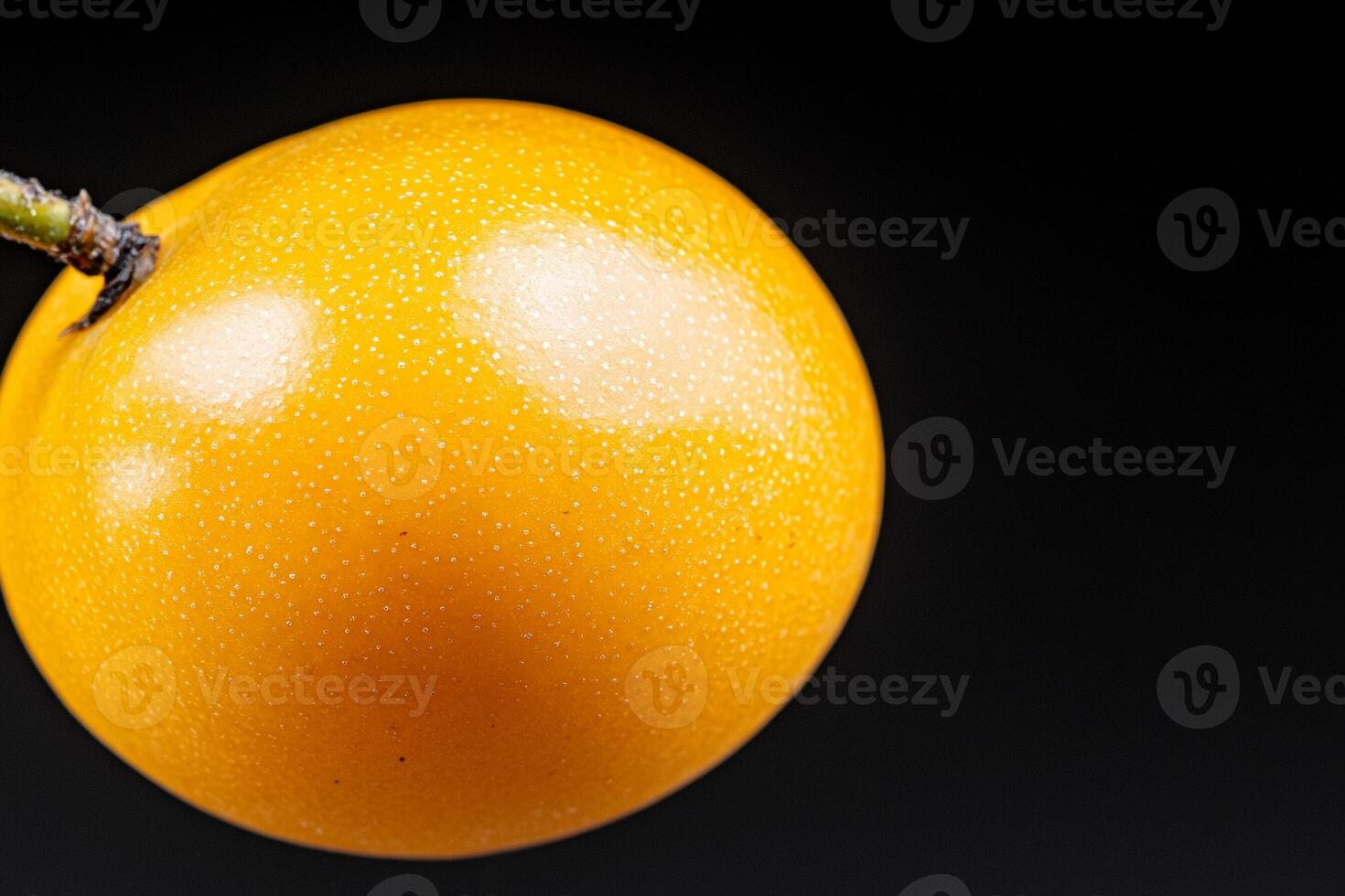 A yellow fruit on a stem photo