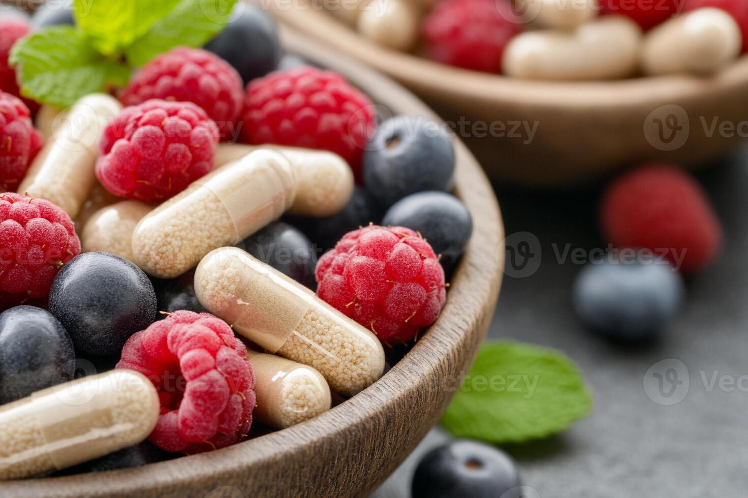A bowl of berries and vitamin pills photo