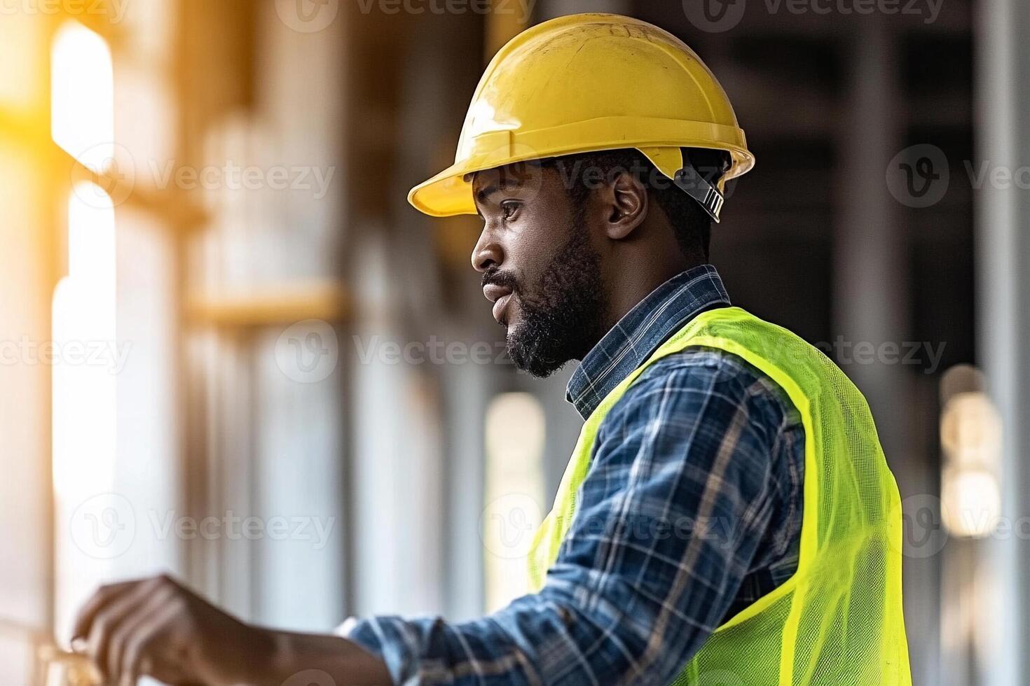 A man in a hard hat and vest is standing in front of a building photo
