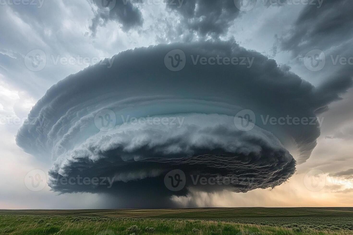 A large storm cloud is seen over a field photo