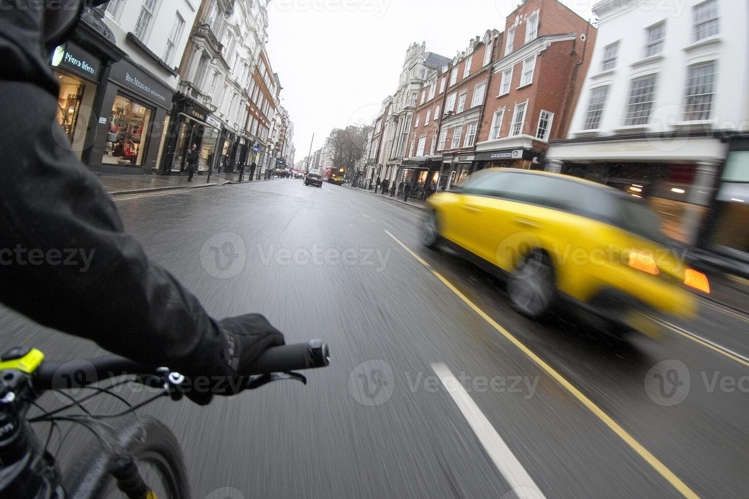 A person riding a bike on a rainy street photo