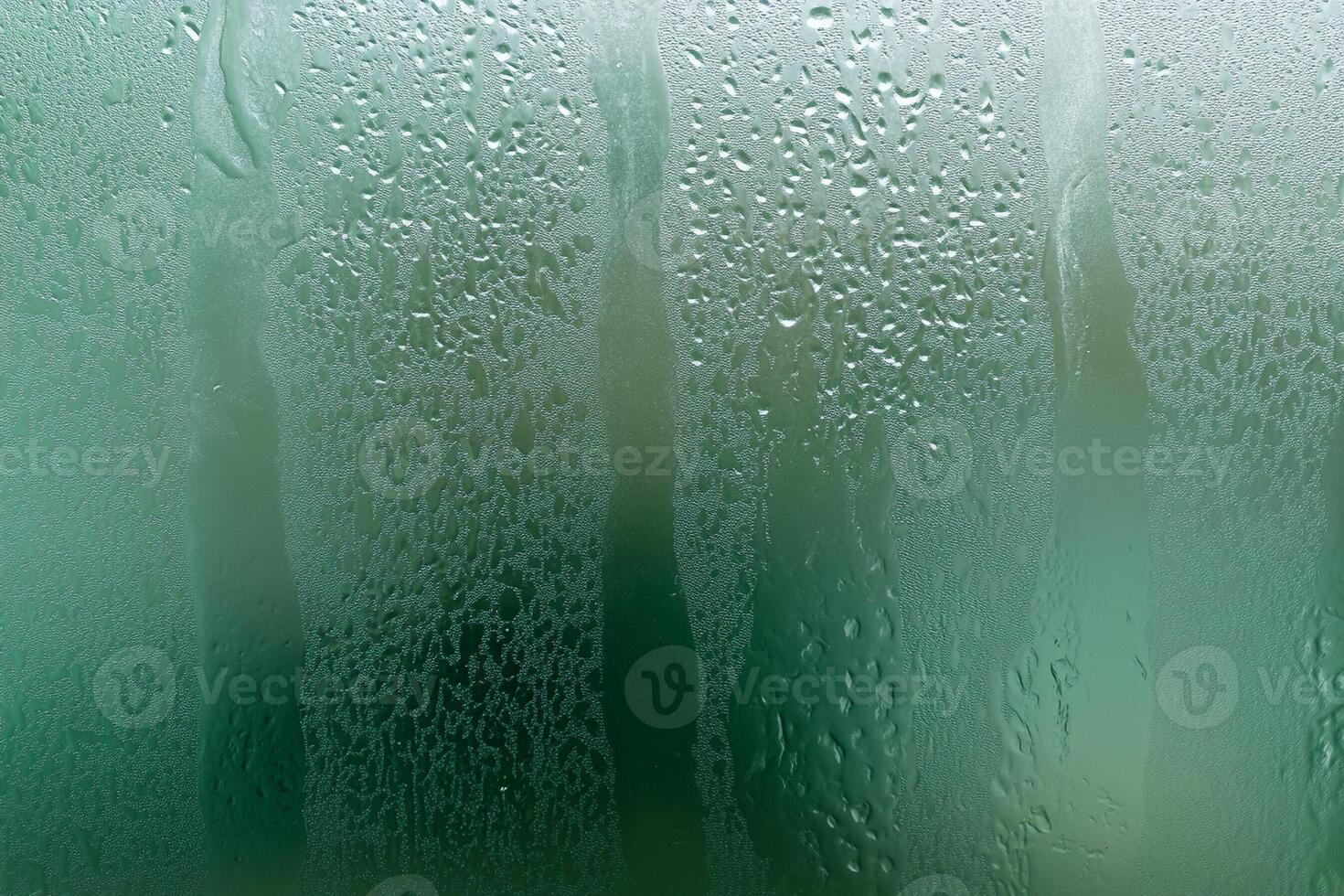 A wet window with water droplets on it photo