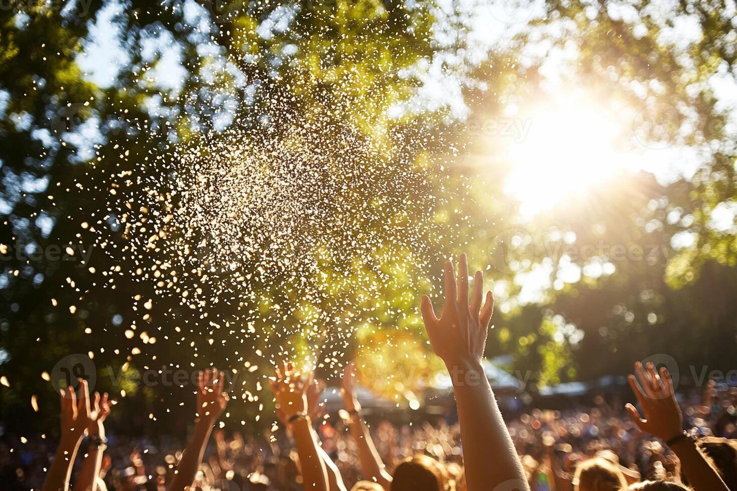 A crowd of people at a music festival with their hands up in the air photo