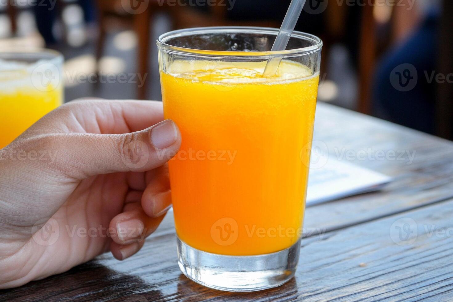 A person holding a glass of orange juice photo