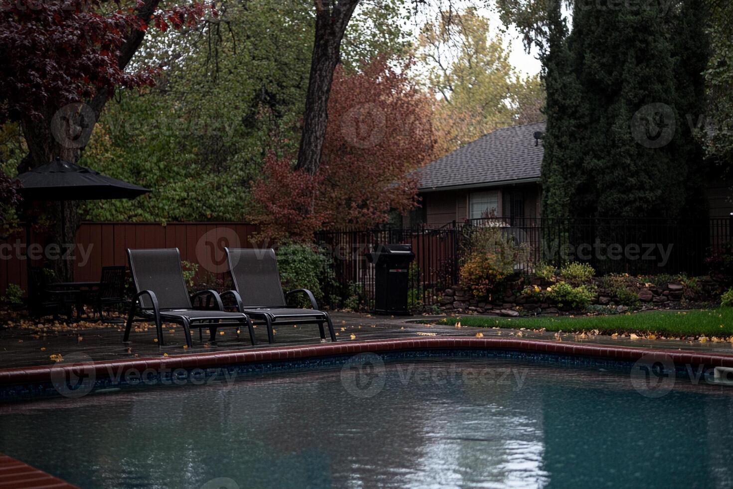 A pool with a lounge chair and umbrella in the backyard photo