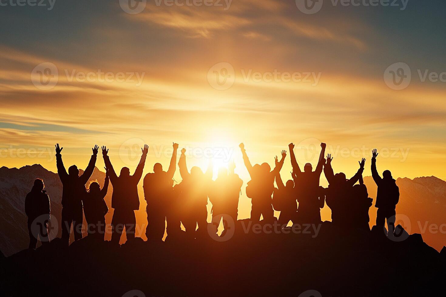 Silhouette of people standing on top of mountain with hands raised in the air photo