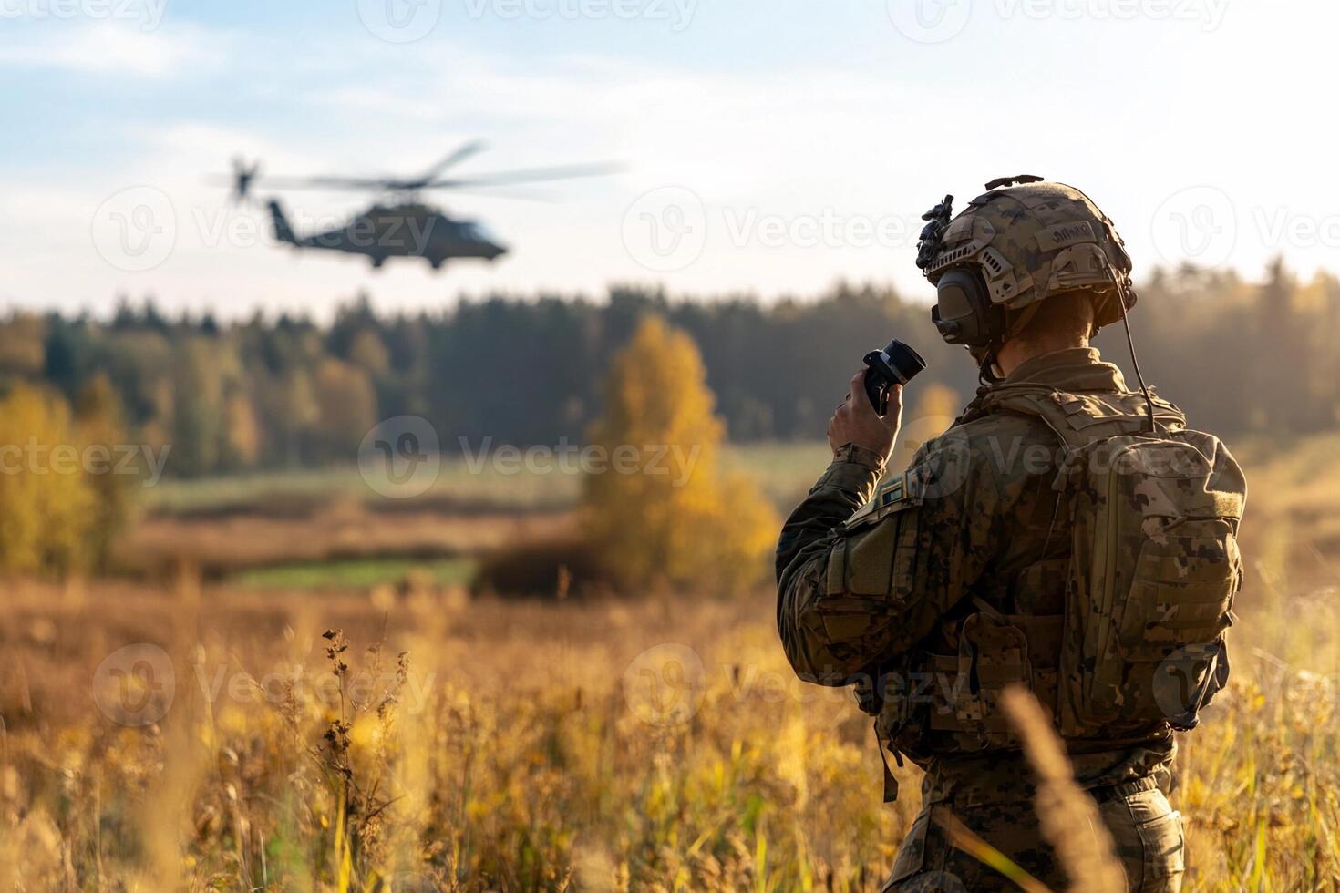 A soldier is looking at a helicopter in the background photo