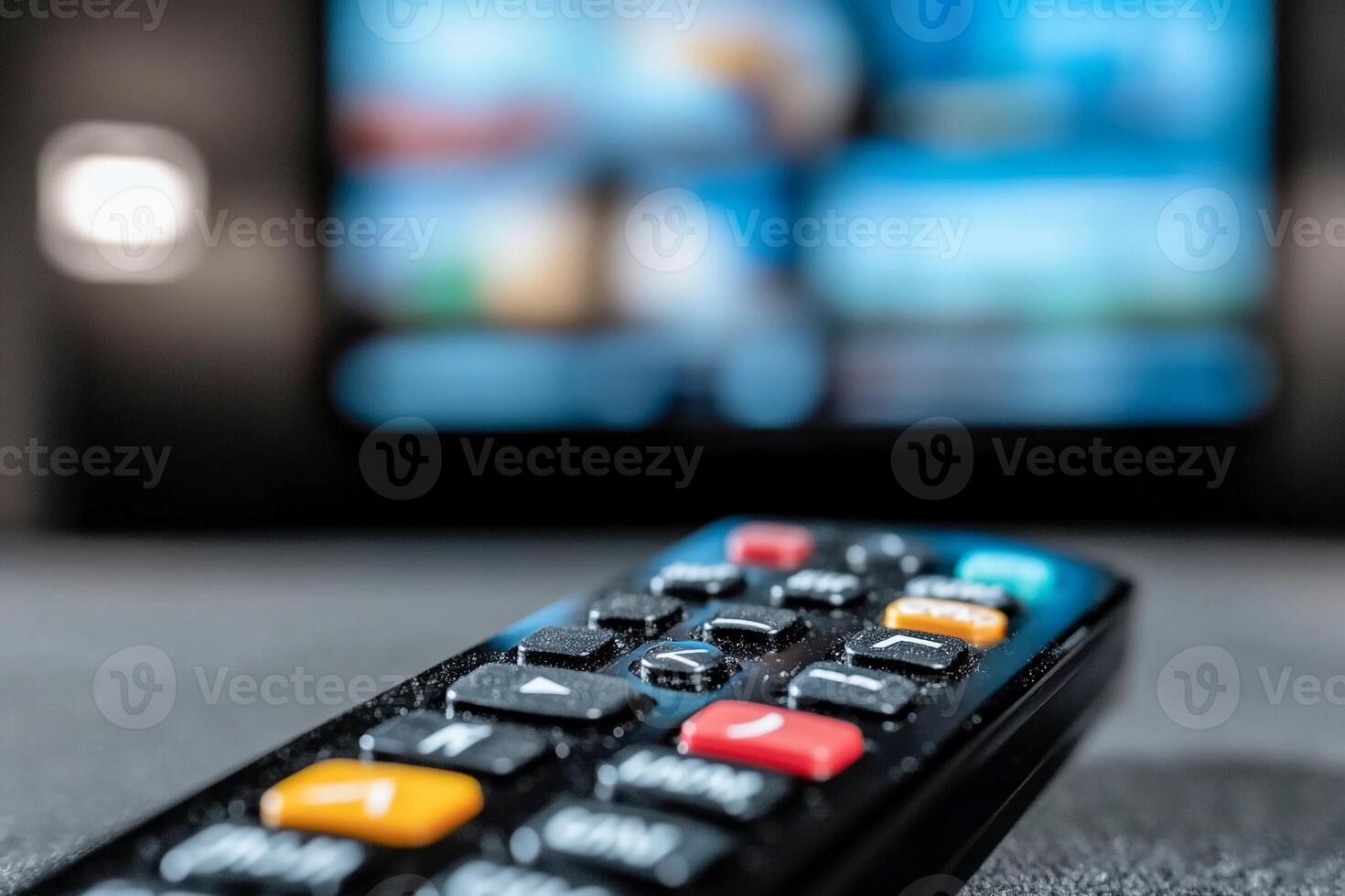 A remote control is shown in front of a television photo