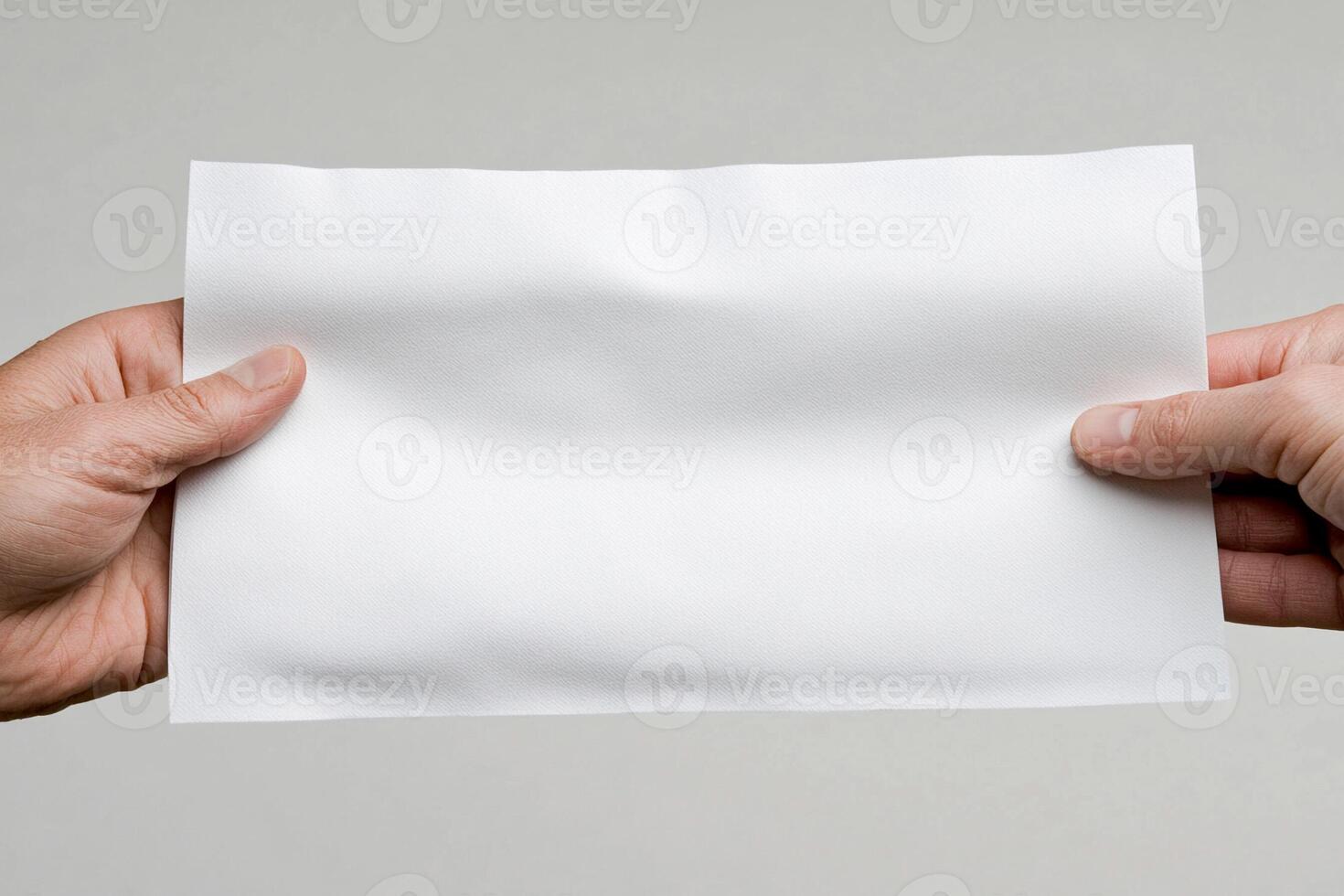 Two hands holding a piece of paper with a blank white sheet photo