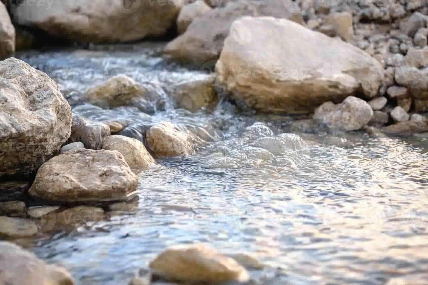 A stream of water flows over rocks in a stream photo