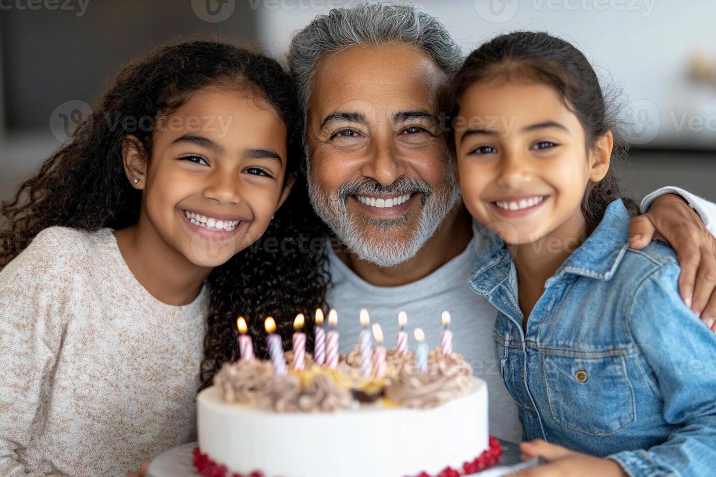 A man and two children are smiling with a cake photo