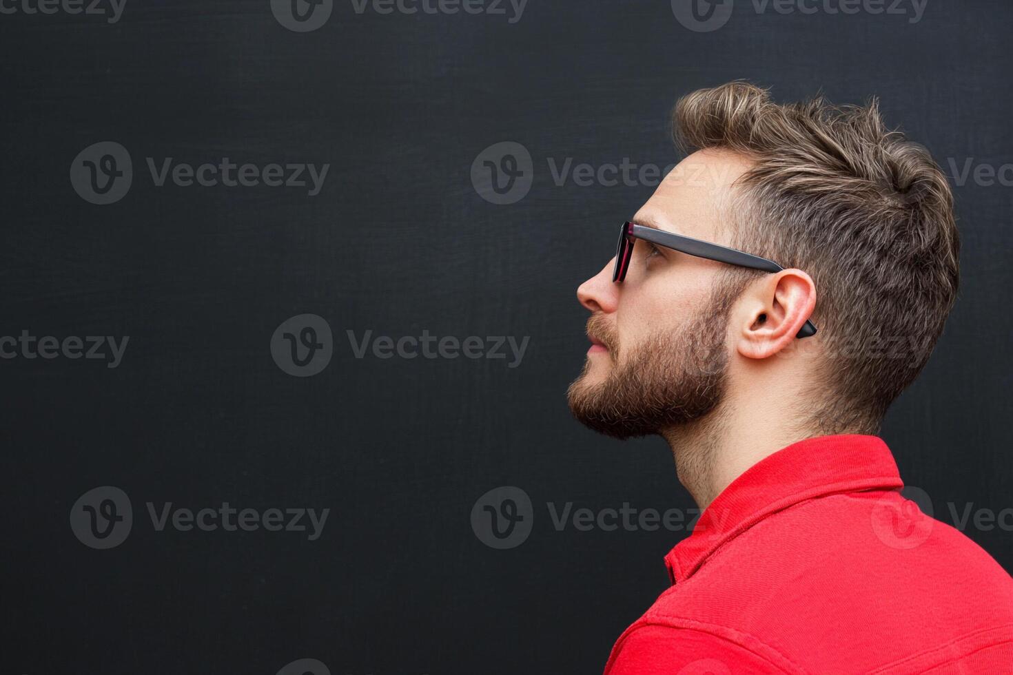 A man in a red shirt and glasses looking up photo